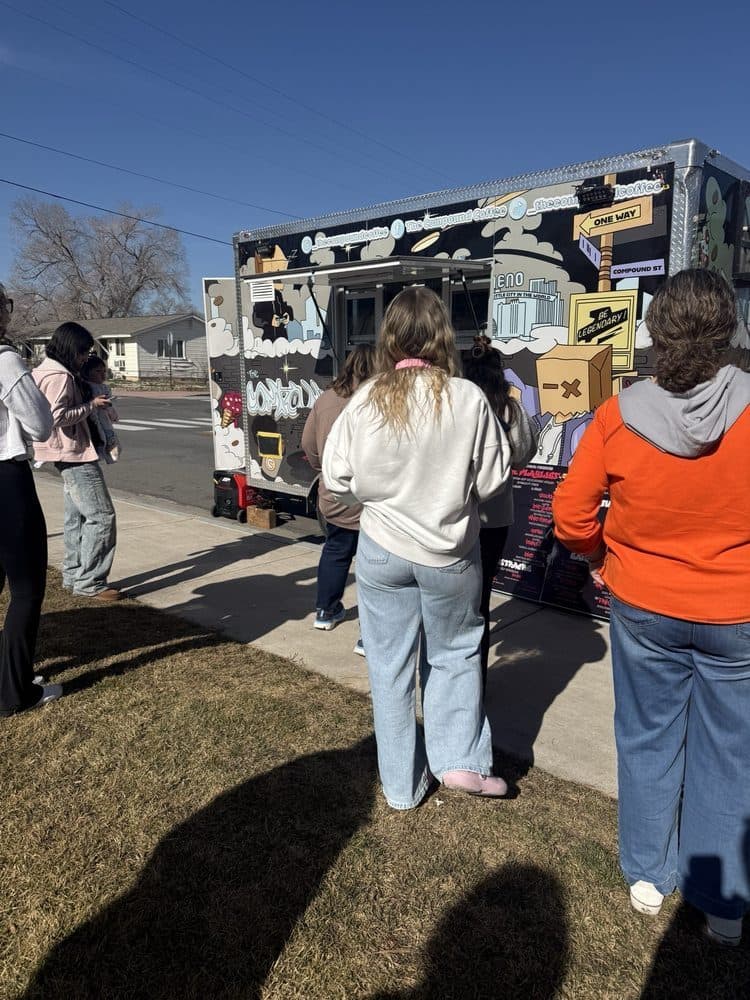 A line of customers waiting at the truck on a sunny day